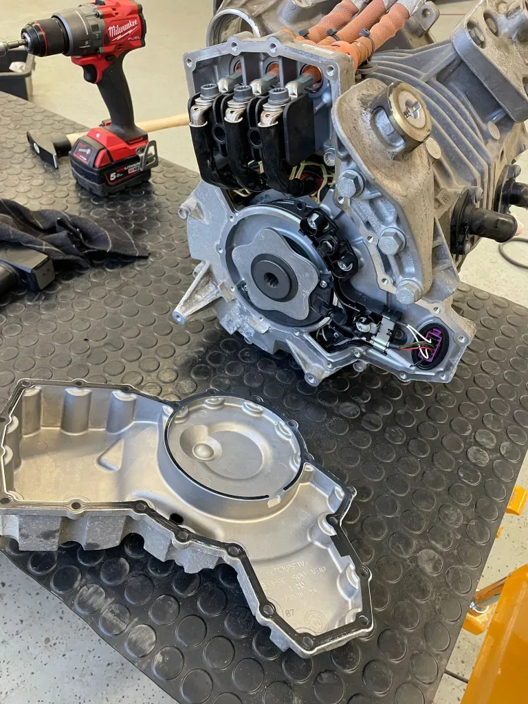 An electric drive unit opened on the bench, end cover removed.